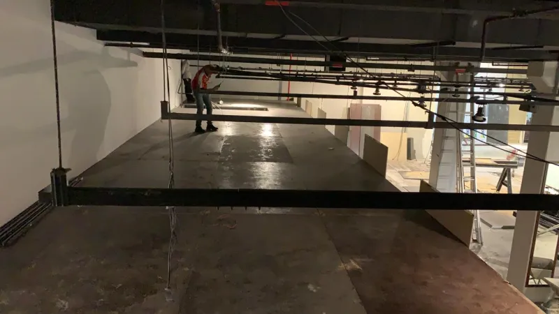 Vigas do mezanino fixadas sob a laje, com montador ao fundo