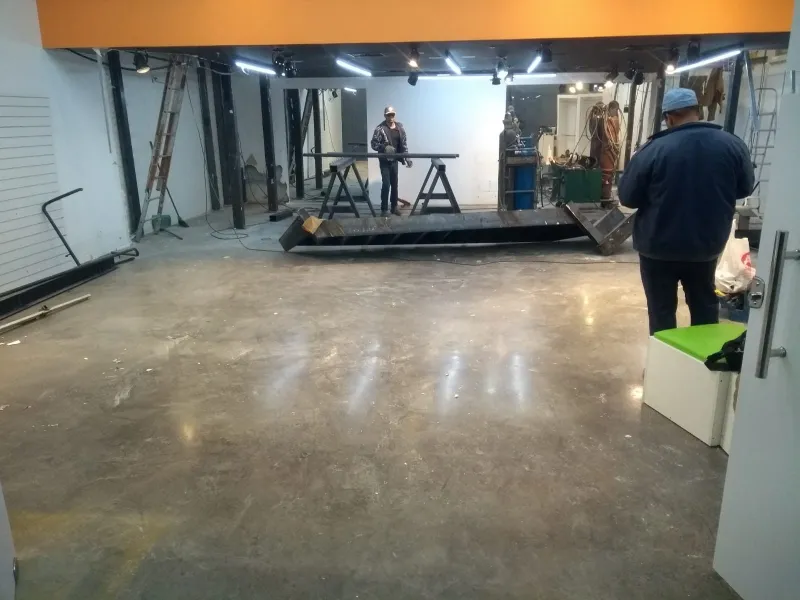 Estrutura do mezanino montada no salão, com montadores ao fundo