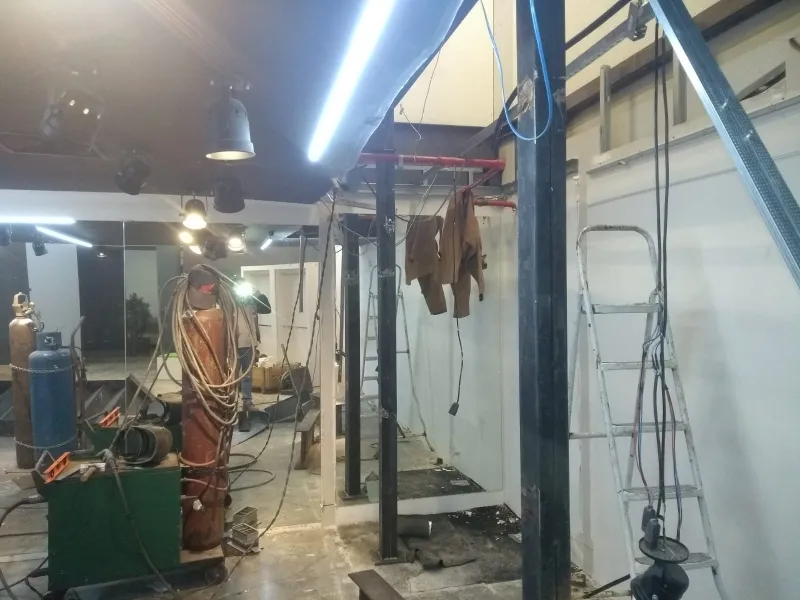 Pilares e pendurais do mezanino, com equipamentos de solda no salão