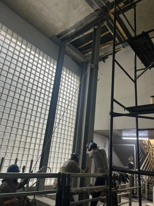 Montadores posicionando um pilar da torre do elevador