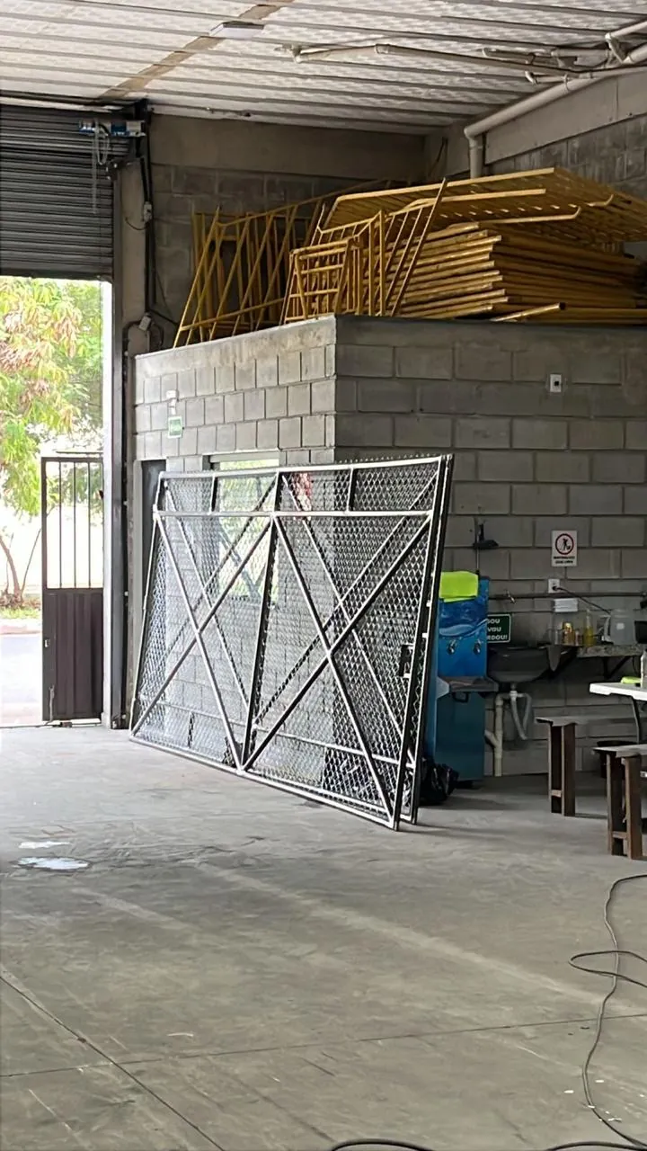 Portão tubular com tela concluído, encostado na parede da fábrica