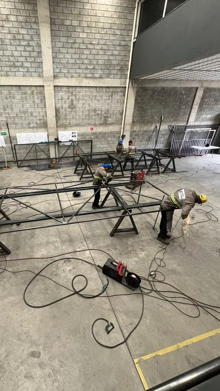 Equipe soldando e cortando os quadros tubulares dos portões, vista do alto