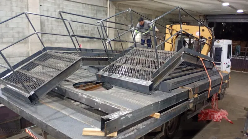 Escadas e plataforma metálicas carregadas no caminhão para o transporte